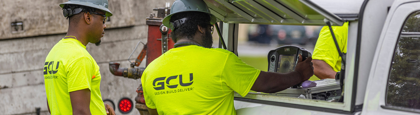 two workers inspecting a screen